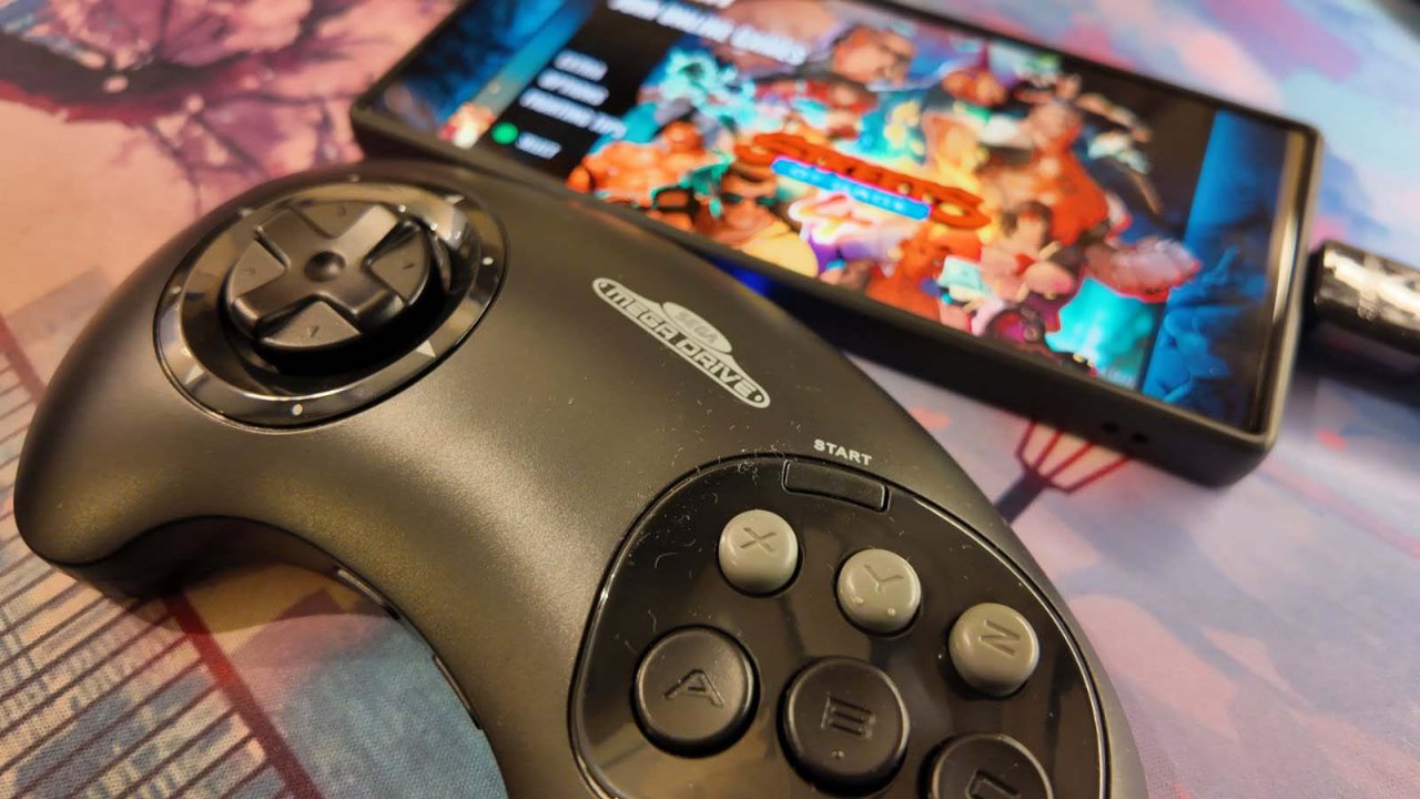 retro-bit sega mega drive controller with streets of rage on a phone in the background