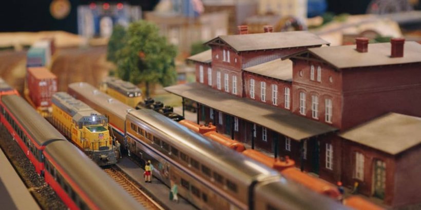Model trains parked at an old fashioned red train station
